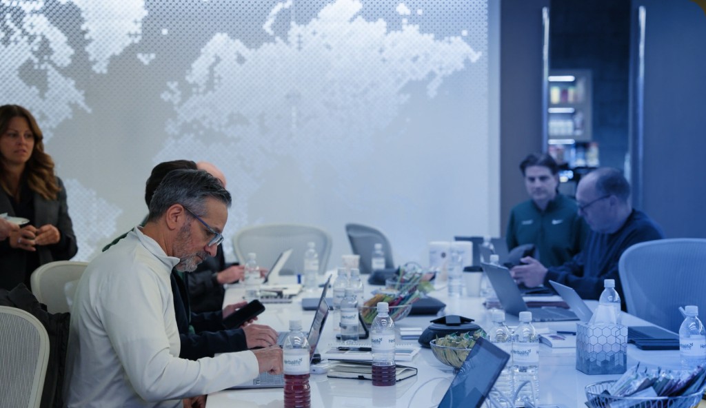 Leaders collaborating around a conference table with laptops in a modern meeting room